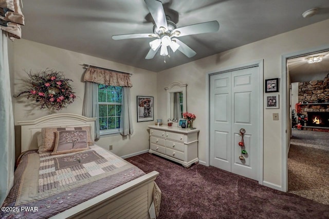 107 Musket Dr, Lackawaxen, PA 18435 - bedroom with dark colored carpet, baseboards, ceiling fan, a stone fireplace, and a closet