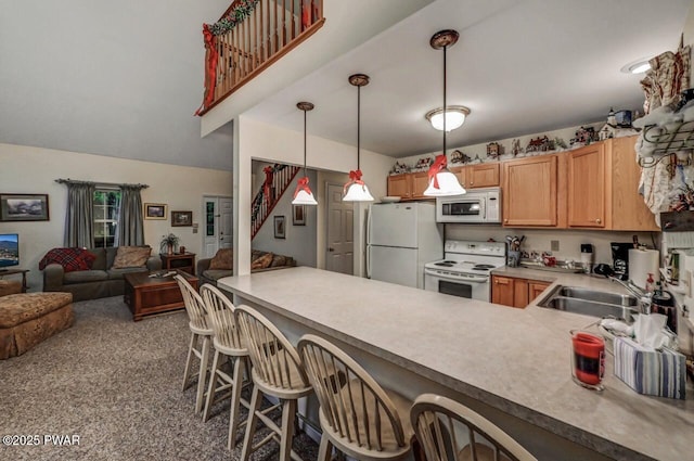 107 Musket Dr, Lackawaxen, PA 18435 - kitchen with white appliances, a sink, a peninsula, open floor plan, and hanging light fixtures