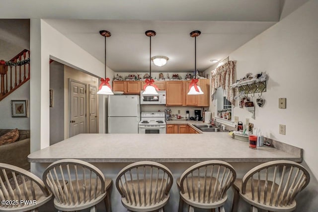 107 Musket Dr, Lackawaxen, PA 18435 - kitchen featuring white appliances, a peninsula, a sink, a breakfast bar area, and decorative light fixtures