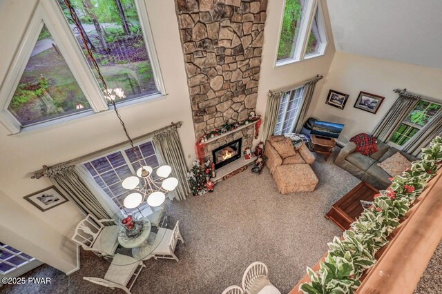 107 Musket Dr, Lackawaxen, PA 18435 - carpeted living room with a chandelier, a towering ceiling, and a fireplace
