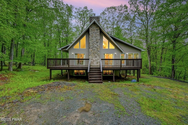 107 Musket Dr, Lackawaxen, PA 18435 - back of house at dusk with a chimney and a wooden deck
