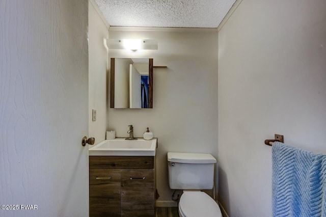 bathroom with a textured ceiling, vanity, and toilet