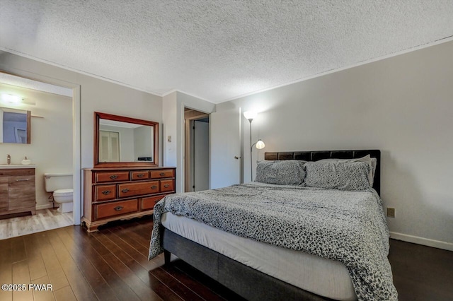 bedroom with crown molding, baseboards, ensuite bathroom, dark wood-style floors, and a textured ceiling