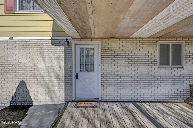 view of exterior entry featuring brick siding