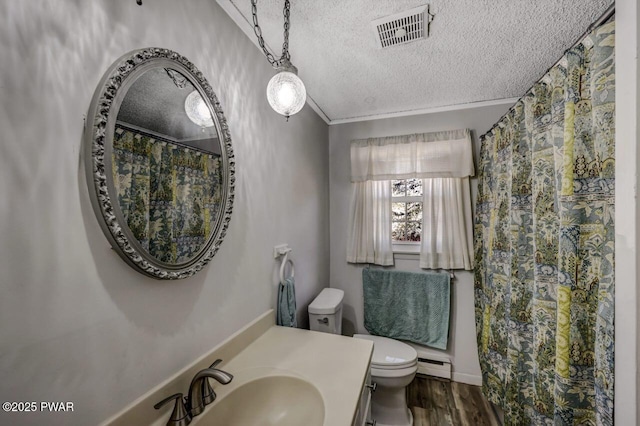 bathroom with visible vents, toilet, a textured ceiling, wood finished floors, and a baseboard radiator