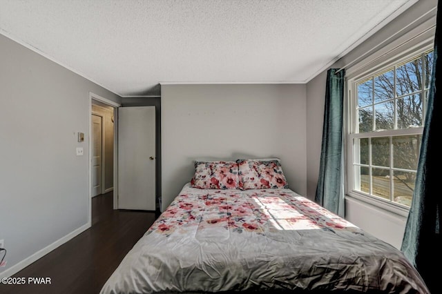 bedroom with dark wood finished floors, a textured ceiling, and baseboards