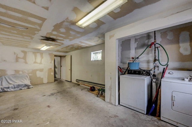 basement featuring baseboard heating and washer and clothes dryer