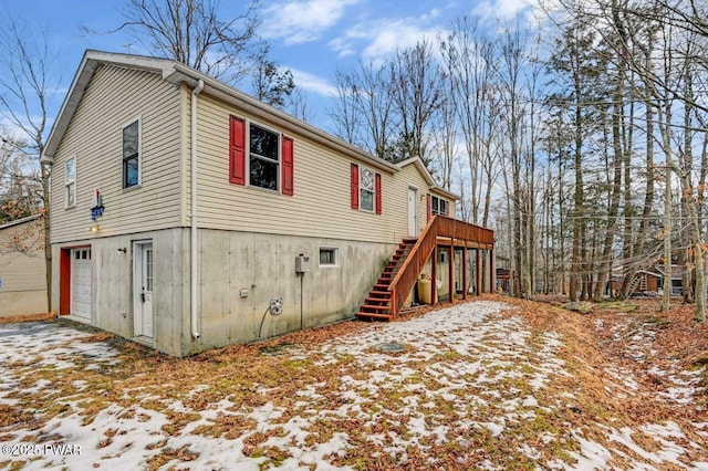 view of snow covered exterior featuring a wooden deck and a garage