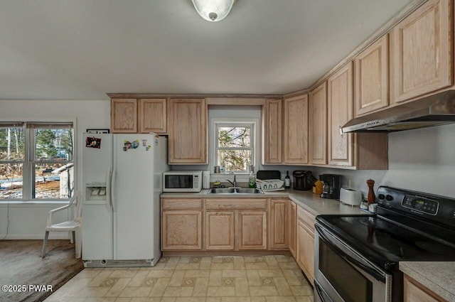 kitchen with sink, light brown cabinetry, and white appliances