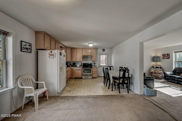 kitchen with stainless steel range with electric stovetop, light brown cabinetry, white refrigerator with ice dispenser, and light carpet