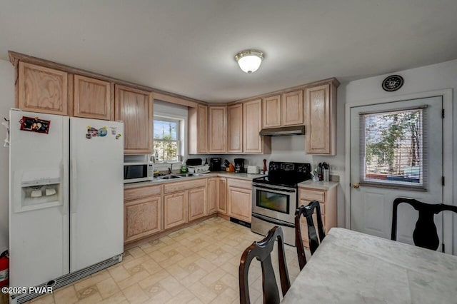 kitchen with white appliances, sink, and light brown cabinets