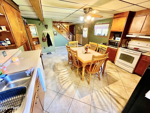 dining space featuring a drop ceiling, ceiling fan, sink, and beam ceiling