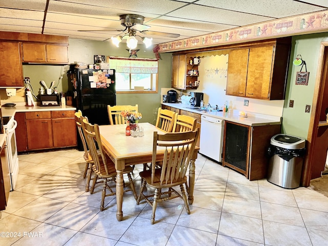 kitchen featuring ceiling fan, a drop ceiling, light tile patterned floors, and white appliances