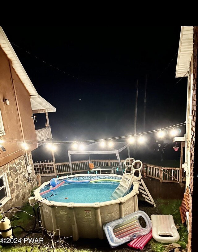 view of pool at twilight