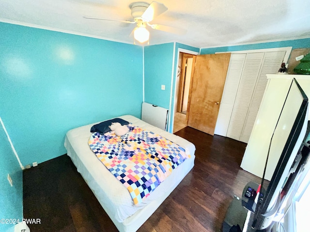 bedroom with ceiling fan, dark hardwood / wood-style floors, and a closet