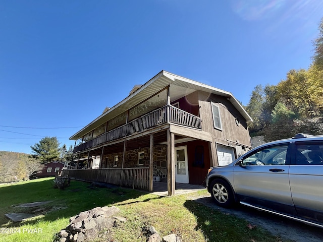 view of property exterior with a yard, a balcony, and a garage