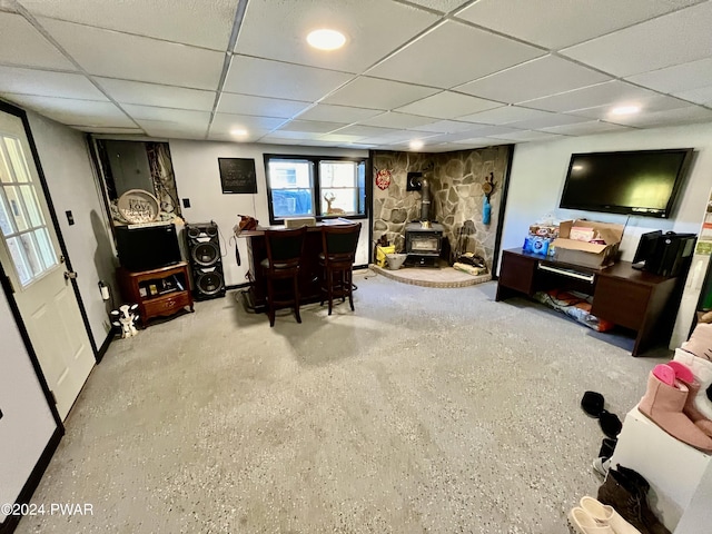 interior space with a wood stove and a drop ceiling