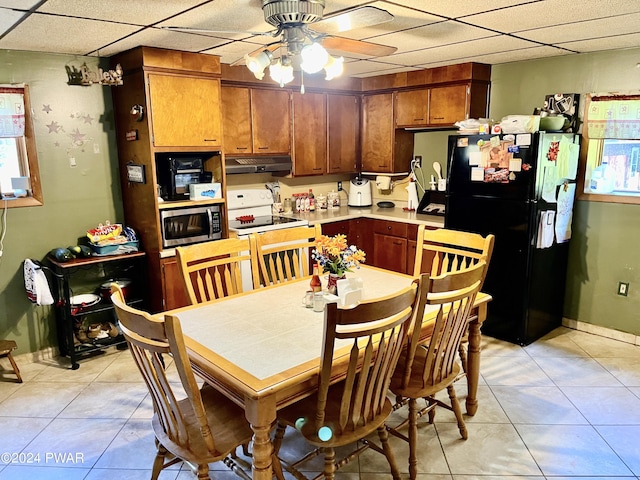 kitchen with a paneled ceiling, black fridge, electric range, and ceiling fan