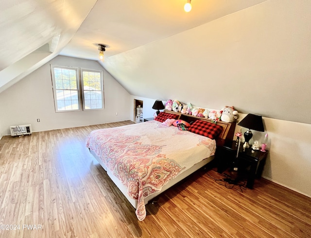 bedroom with hardwood / wood-style floors and vaulted ceiling