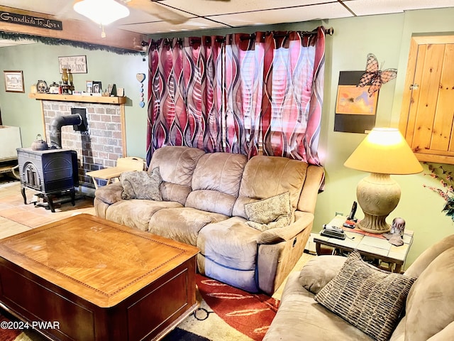 living room featuring a paneled ceiling and a wood stove