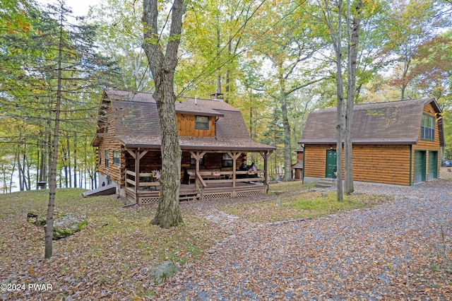 log home featuring a deck with water view and a garage