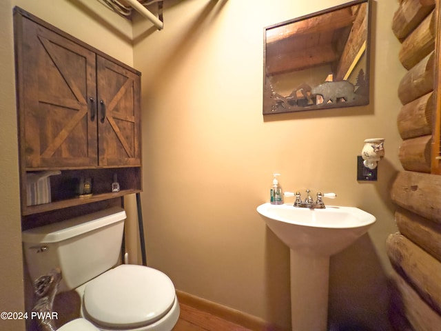 bathroom with wood-type flooring, toilet, and sink