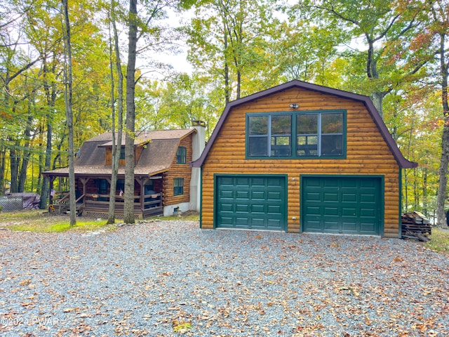 log-style house featuring a garage and an outdoor structure