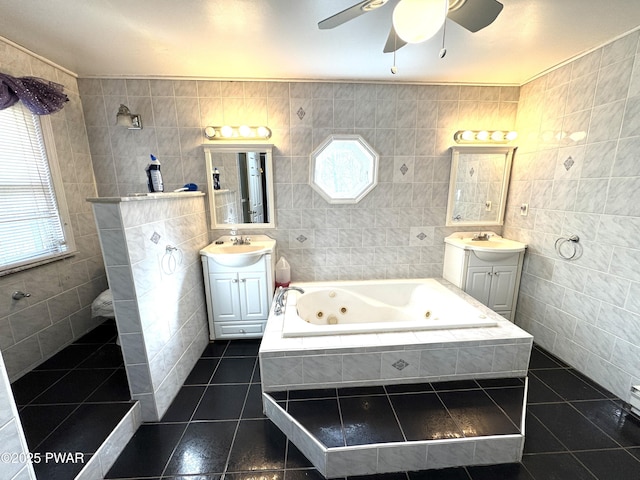 bathroom with tile walls, tiled tub, and vanity