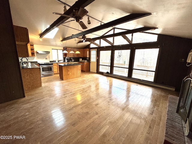 kitchen with stainless steel stove, ceiling fan, a kitchen island, beam ceiling, and decorative light fixtures