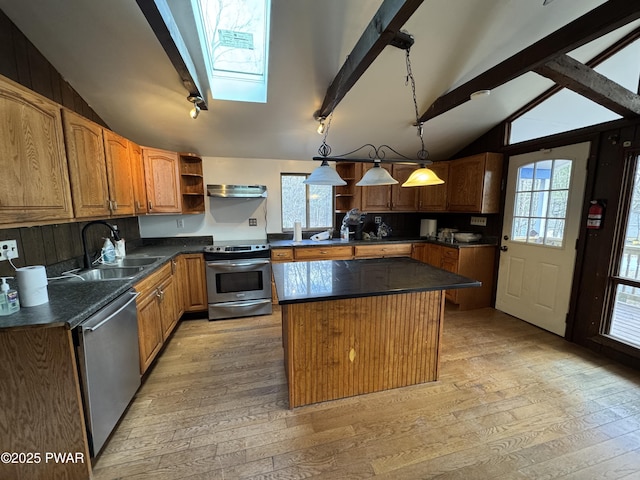 kitchen with a center island, light hardwood / wood-style floors, lofted ceiling with skylight, appliances with stainless steel finishes, and sink