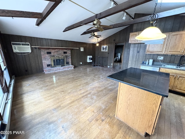 kitchen with wood walls, ceiling fan, a wall mounted air conditioner, and a center island