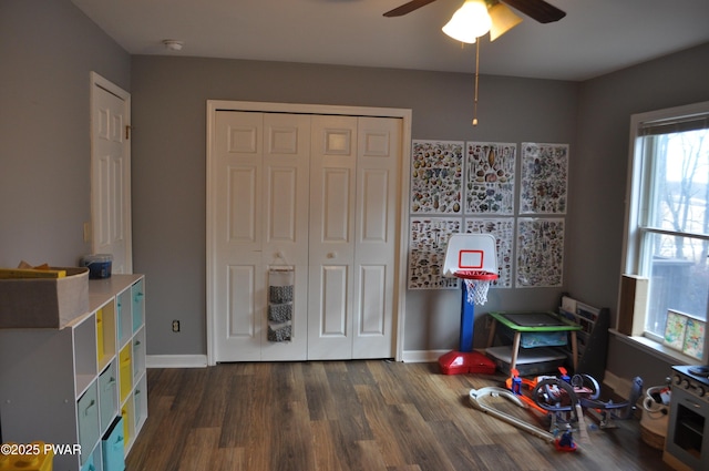 game room featuring dark wood-style floors, ceiling fan, and baseboards