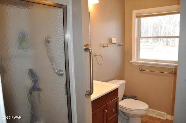 bathroom featuring tile patterned flooring, toilet, vanity, visible vents, and a stall shower