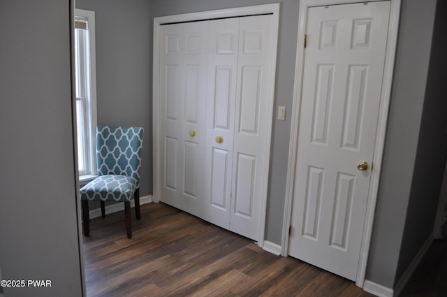 bedroom with a closet, baseboards, and dark wood-type flooring