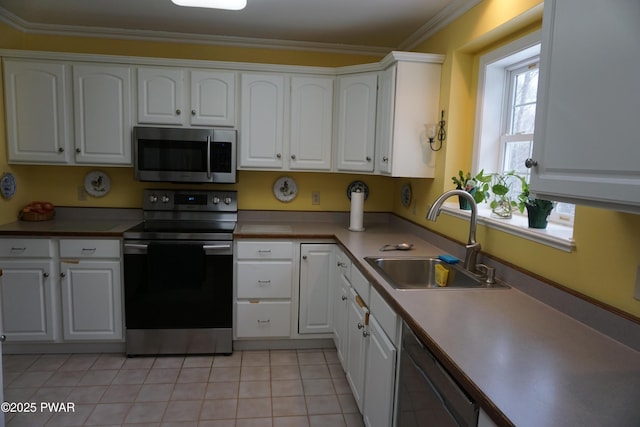 kitchen with white cabinetry, ornamental molding, stainless steel appliances, and sink