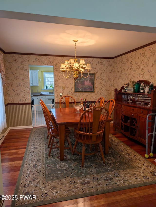 dining area with an inviting chandelier, ornamental molding, and dark hardwood / wood-style floors