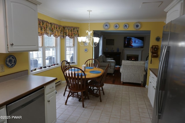 tiled dining room with a baseboard heating unit and ornamental molding