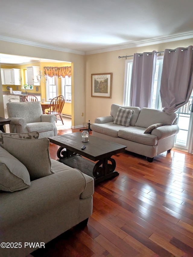 living room with dark wood-type flooring, ornamental molding, and a healthy amount of sunlight