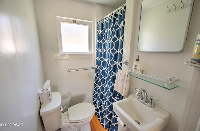 bathroom featuring toilet, curtained shower, and sink