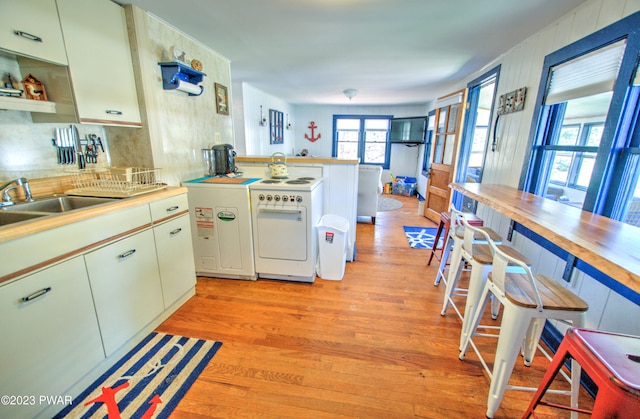 kitchen featuring light hardwood / wood-style floors, white range, and sink