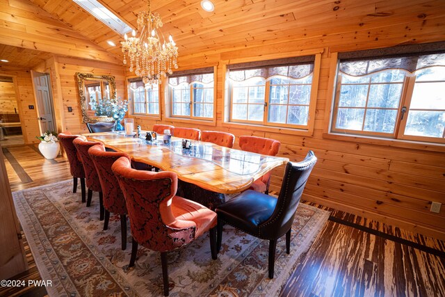 dining area with hardwood / wood-style floors, a chandelier, wooden walls, and vaulted ceiling