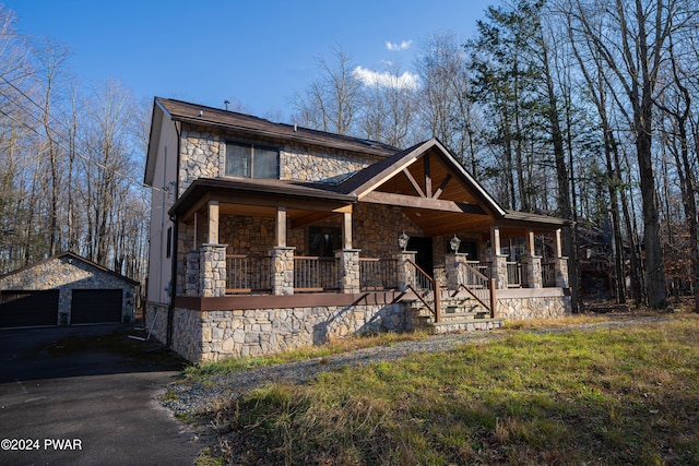 view of front of property with an outdoor structure, a porch, and a garage