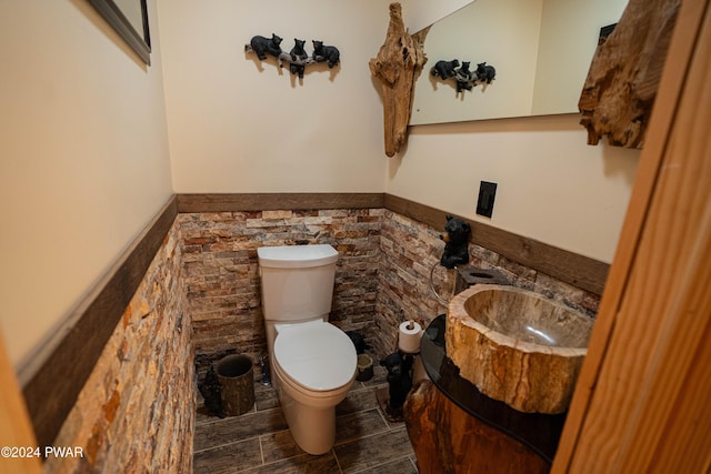 bathroom with vanity, toilet, and tile walls