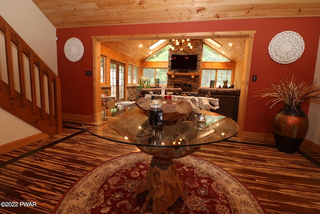 dining area featuring a stone fireplace, a healthy amount of sunlight, wooden ceiling, and lofted ceiling