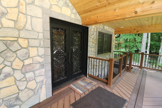 view of exterior entry with a wooden deck and french doors