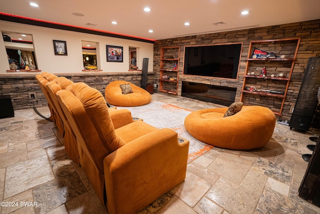 living room featuring a stone fireplace and ornamental molding