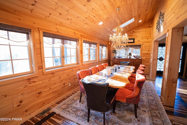 dining room featuring a skylight, wooden ceiling, high vaulted ceiling, a notable chandelier, and wooden walls