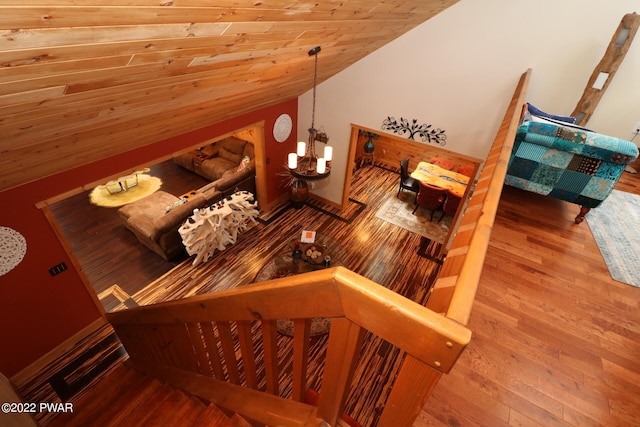 stairway with hardwood / wood-style flooring, lofted ceiling, wood ceiling, and an inviting chandelier