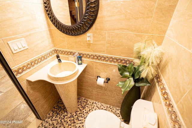 bathroom featuring toilet and tile walls