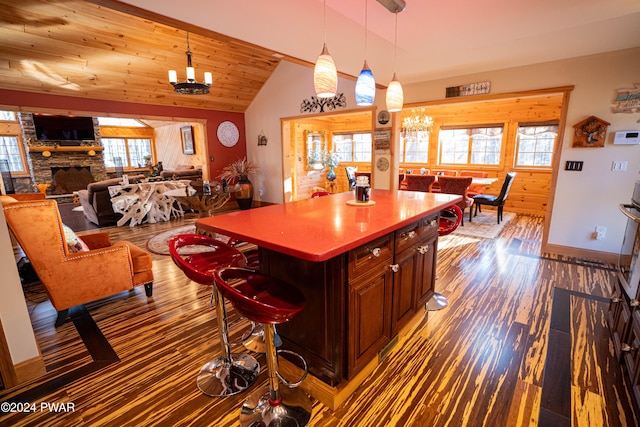 kitchen with a fireplace, a healthy amount of sunlight, an inviting chandelier, and a kitchen island